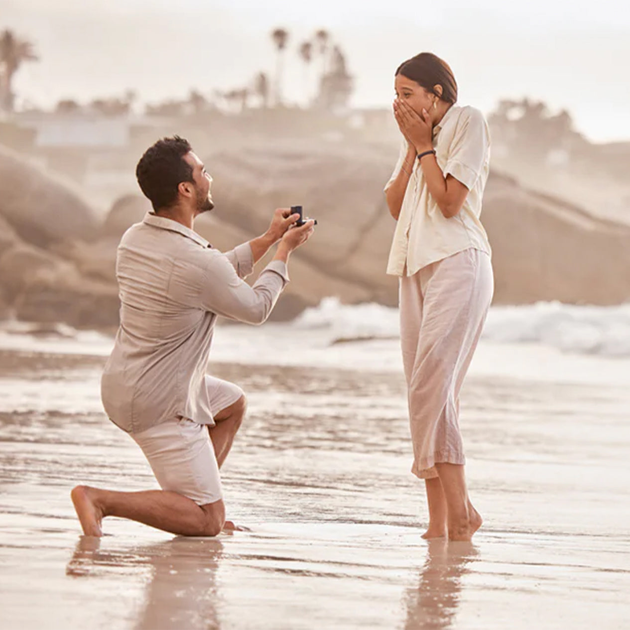 Man proposing to his surprised girlfriend on the beach with Shimansky Jewellery
