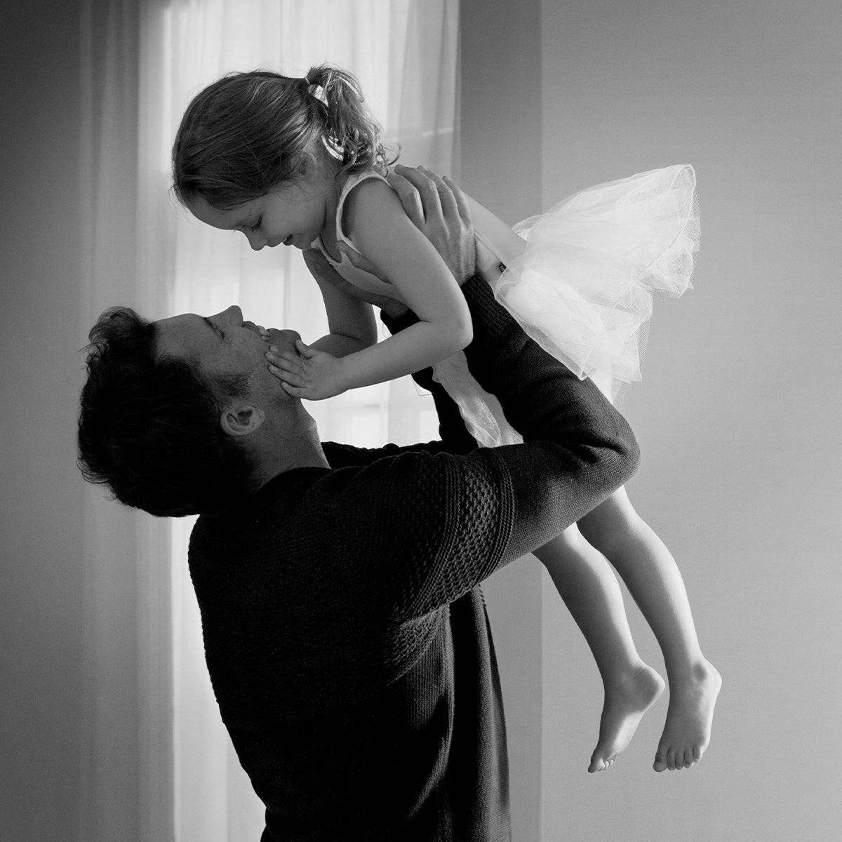 Father celebrating holding his daughter in the air
