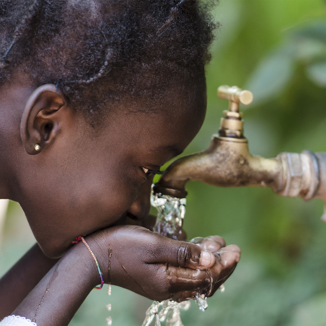 Girl drinking water out of a tap