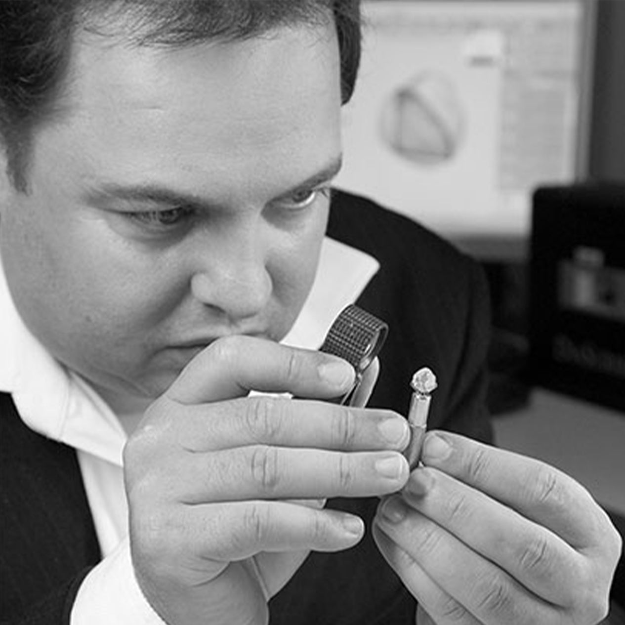 CEO Yair Shimansky closely inspecting a diamond.
