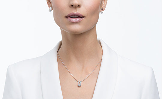 Women in white wearing the signature Shimansky Millennium Collection earrings and pendant