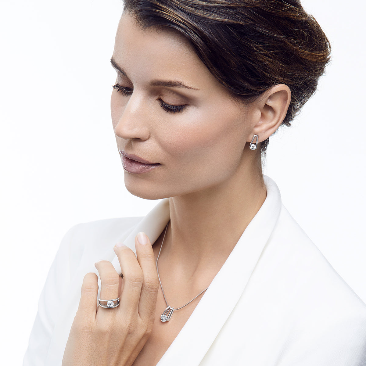 Woman in white wearing the iconic Shimansky Millennium collection set, earrings, pendant and ring 